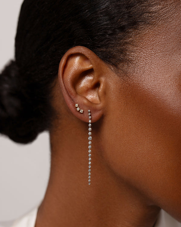 Graduated Diamond Drop Earrings in 14kt white gold shown on ear with the Curved Trio Diamond Studs