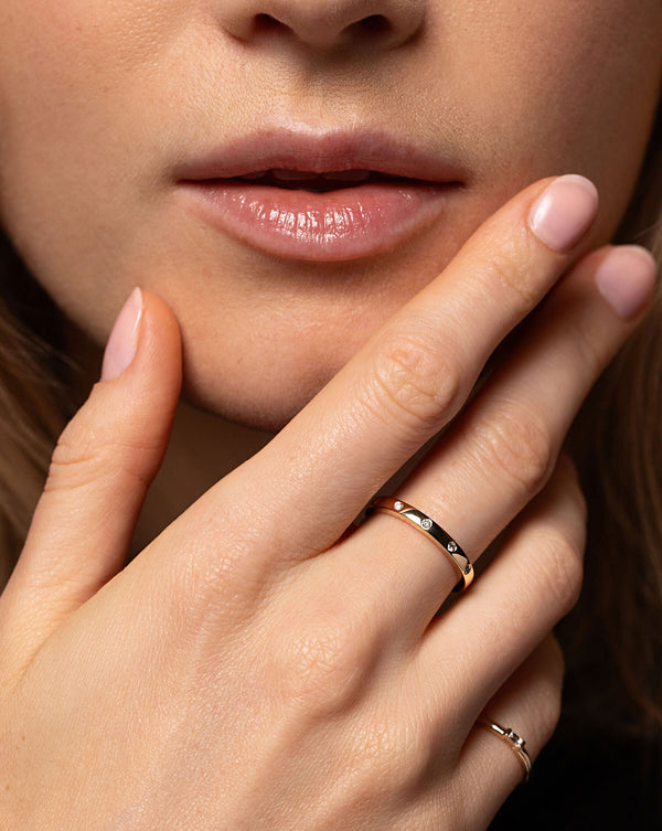 model holding hand close to face wearing inlay diamond ring