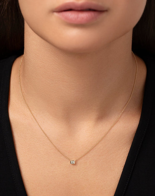 14k yellow gold bezel-set emerald diamond pendant necklace shown on model
