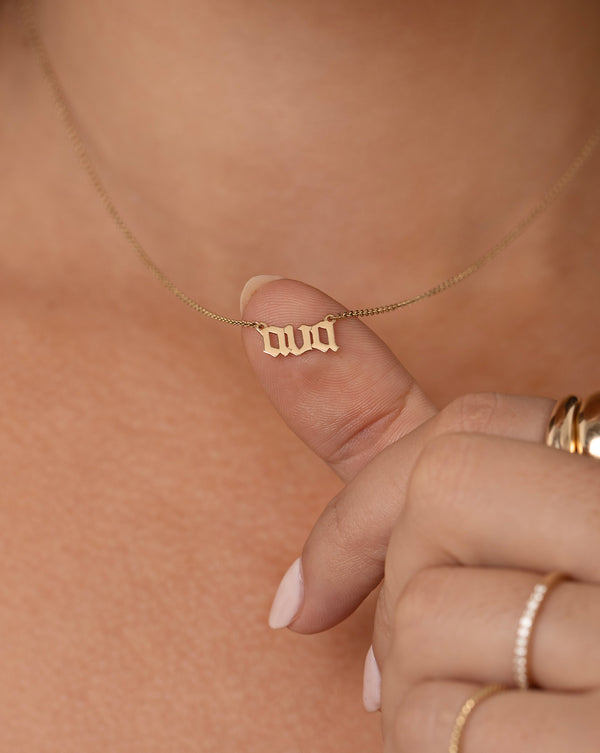 14k yellow gold gothic name Ava necklace shown on model