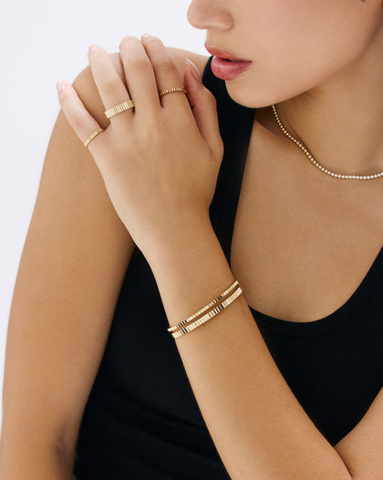 Model wearing Fluted Gold Bangle in elegant hand pose - luxury gold bracelet with ridged texture by Ring Concierge