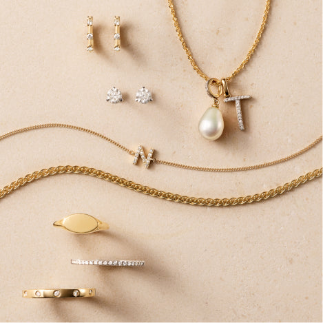 various charms, necklaces, earrings and rings against a travertine background