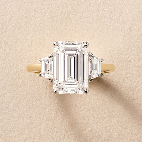 three stone engagement ring against a travertine background