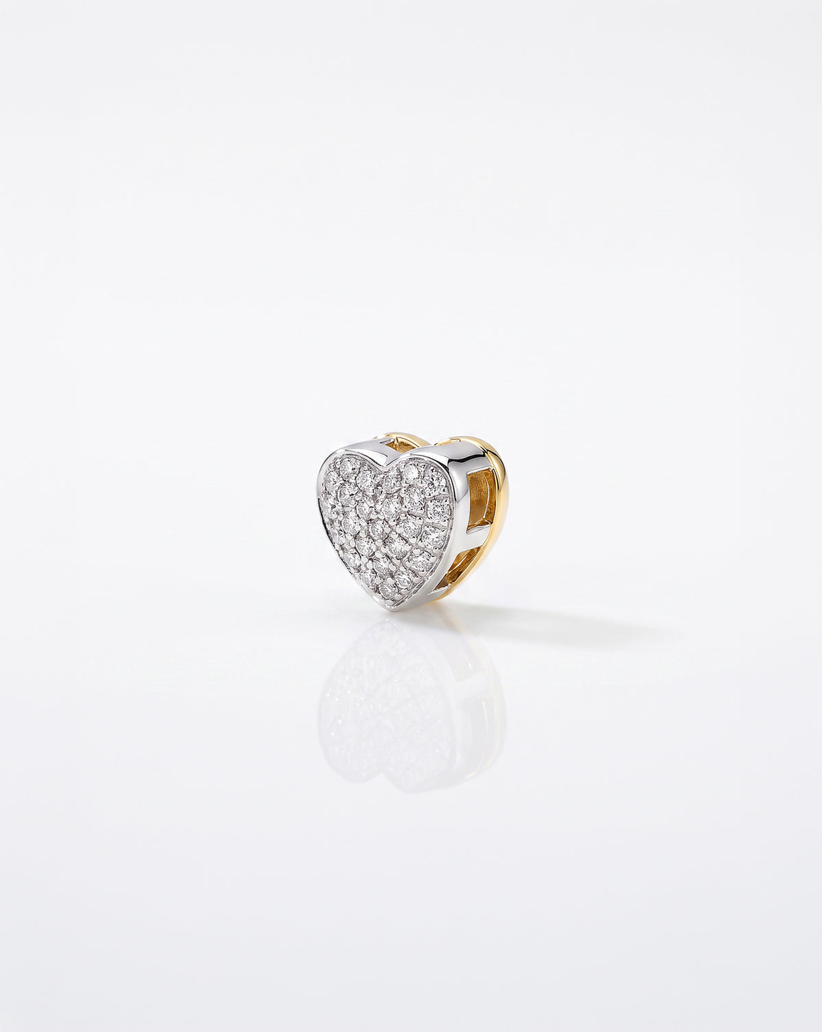 A heart-shaped pave bead, shown on a clean white reflective surface.