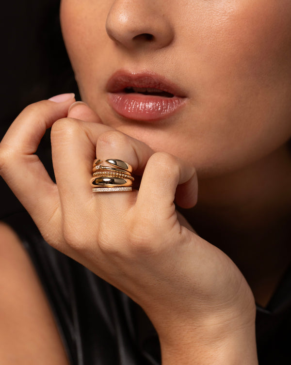 Wide Gold Claw Stackable Ring stacked on model finger with 4 other diamond and gold rings