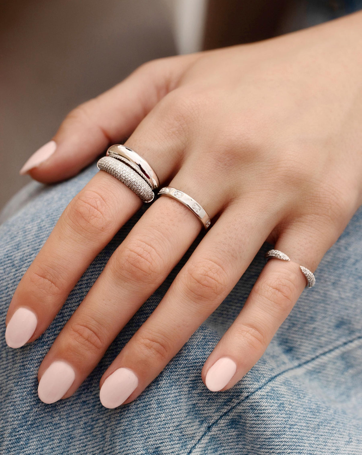 Gold Cloud Ring shown stacked with the Pave Diamond Cloud Ring on pointer finger with model also wearing the Emerald Luxe Inlay Diamond Band and Triple Row Diamond Claw Ring