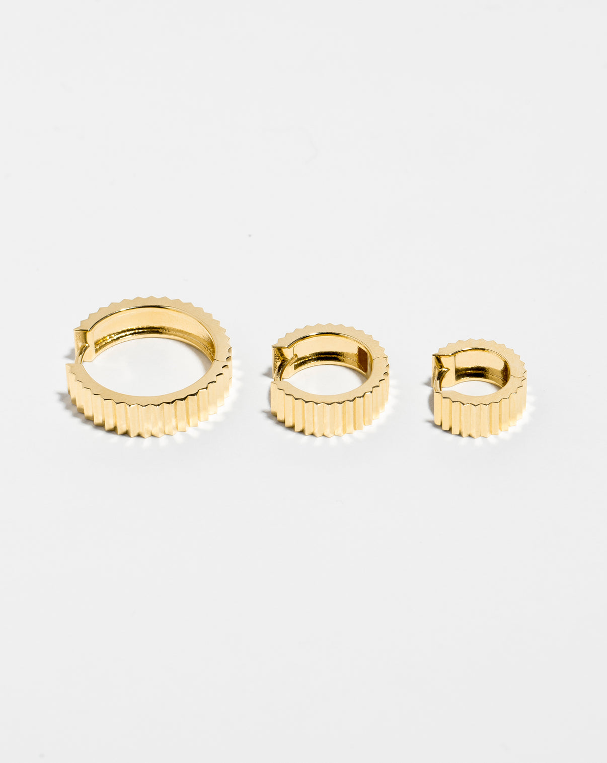 Wide Fluted Gold Hoops in 3 sizes flat lay. global