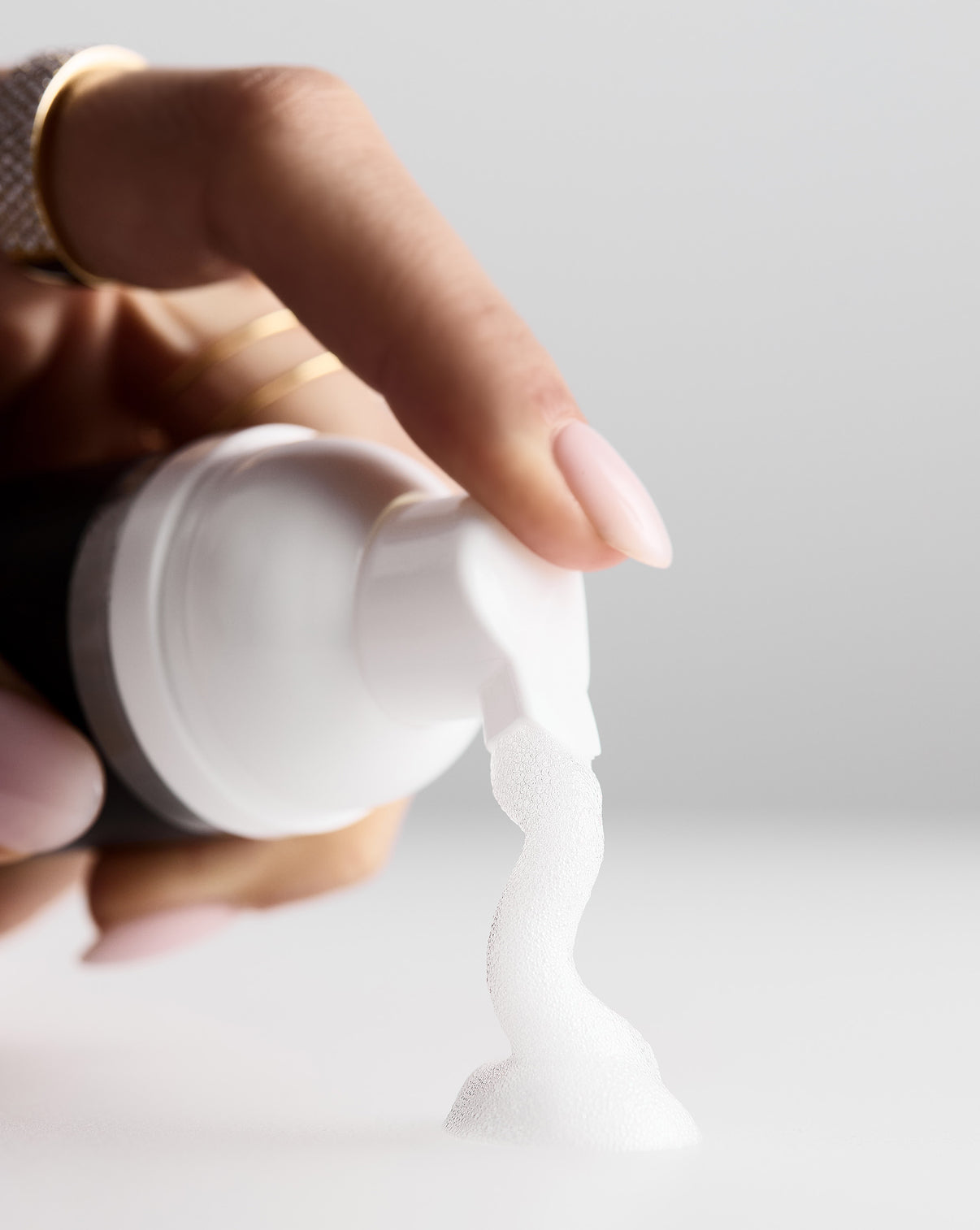 Person pressing on jewelry cleaner and foam coming out