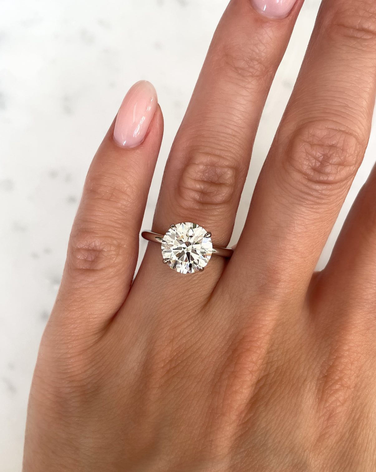 Round Lab Diamond in Cloud Solitaire Hidden Halo close up on hand