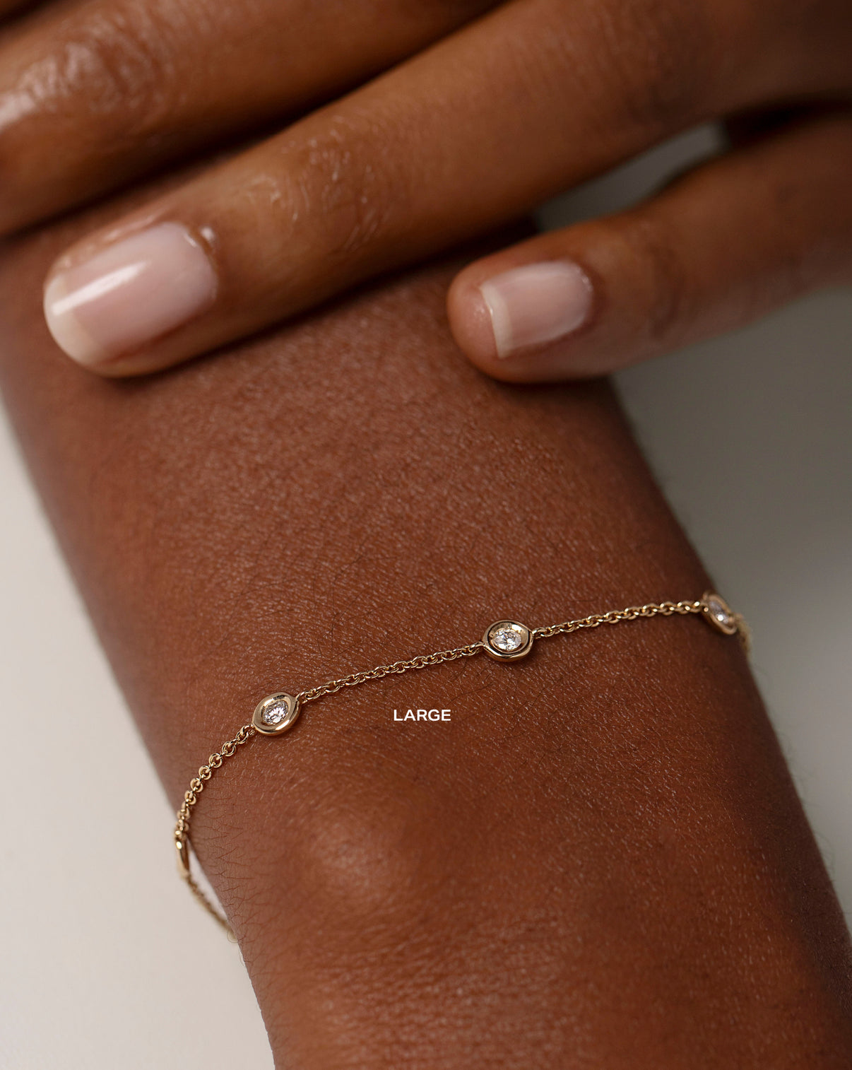 large bezel-set round diamond station bracelet on model LARGE