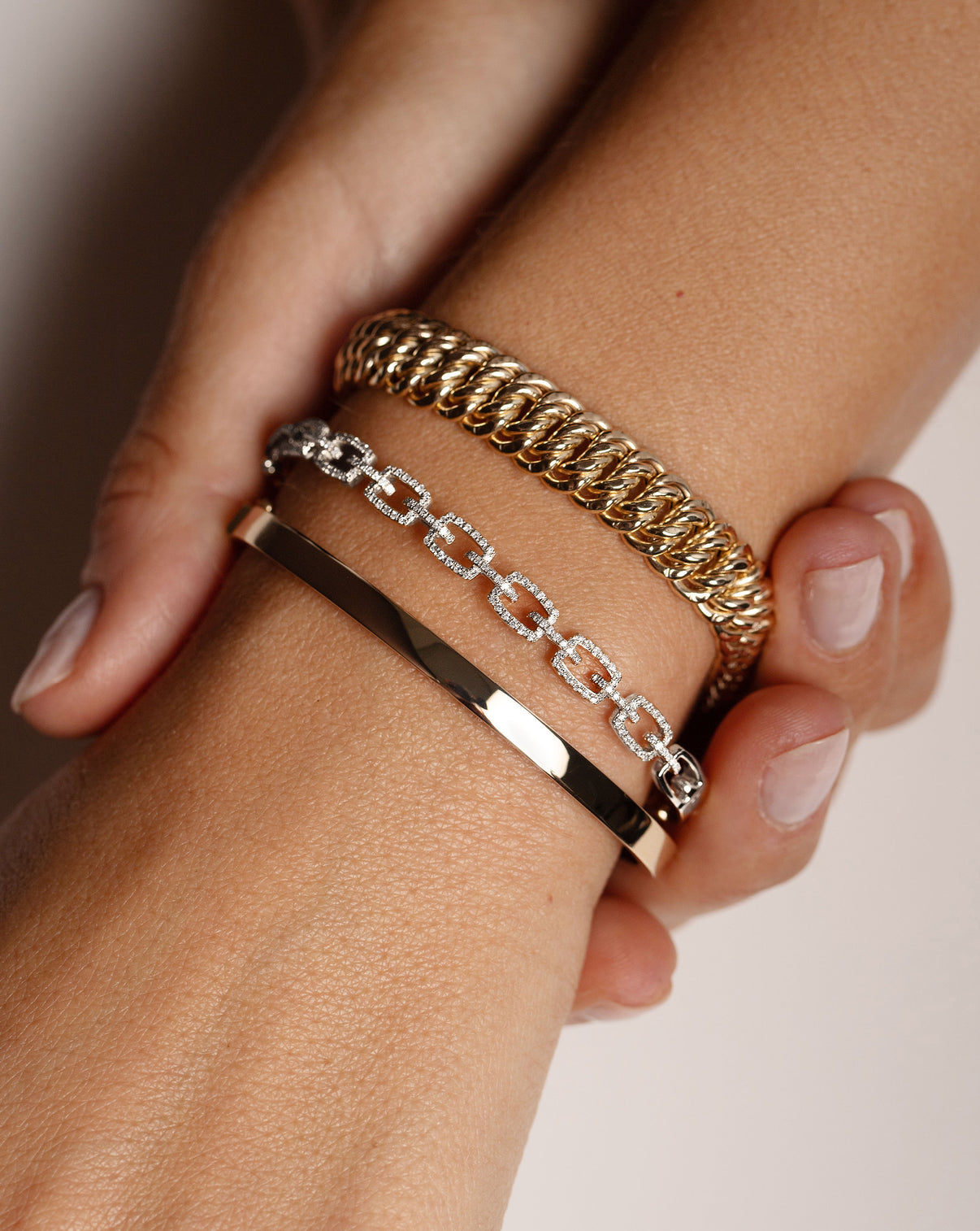 Diamond Link Bangle in White Gold on model styled with 2 other bracelets
