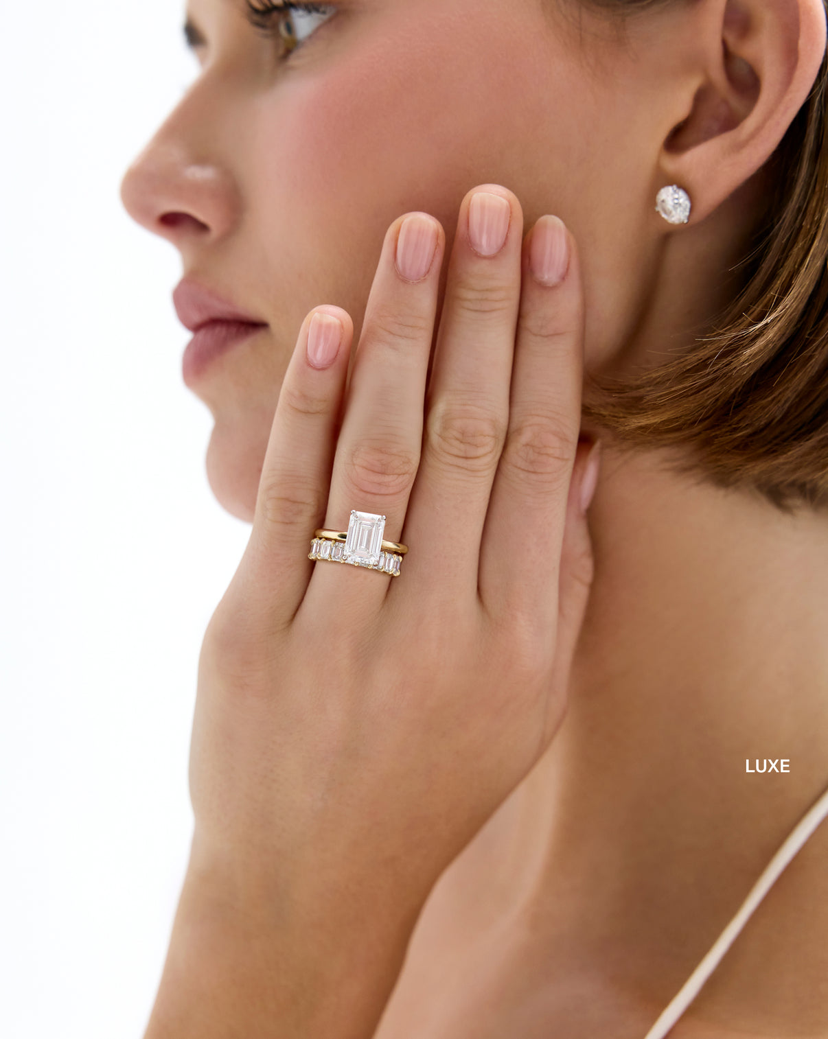 model wearing  luxe 4 carat weight emerald diamond eternity band stacked with diamond engagement ring global