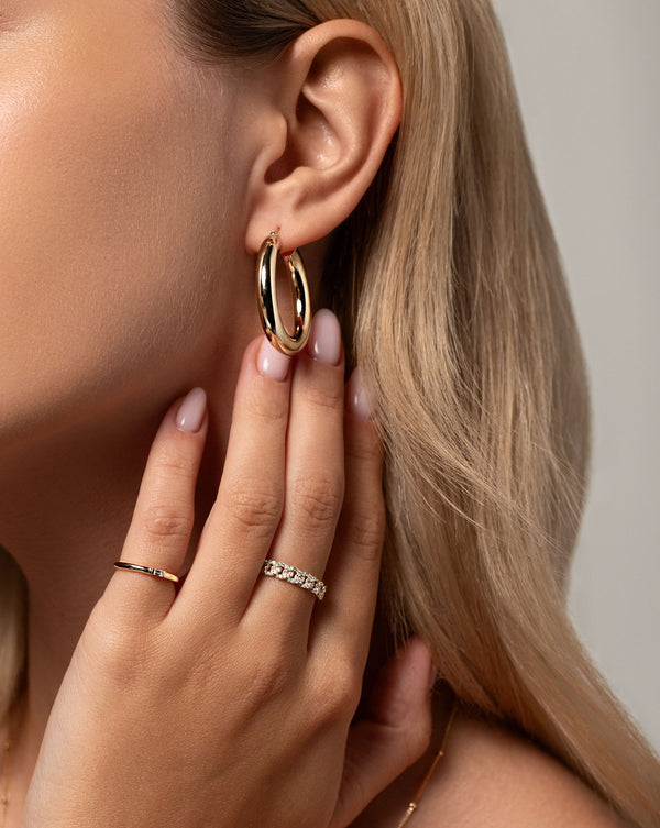 4 mm tube hoop shown in ear of model. Model is also wearing the Pave Diamond Chain Ring and Single Baguette Diamond Ring on hand
