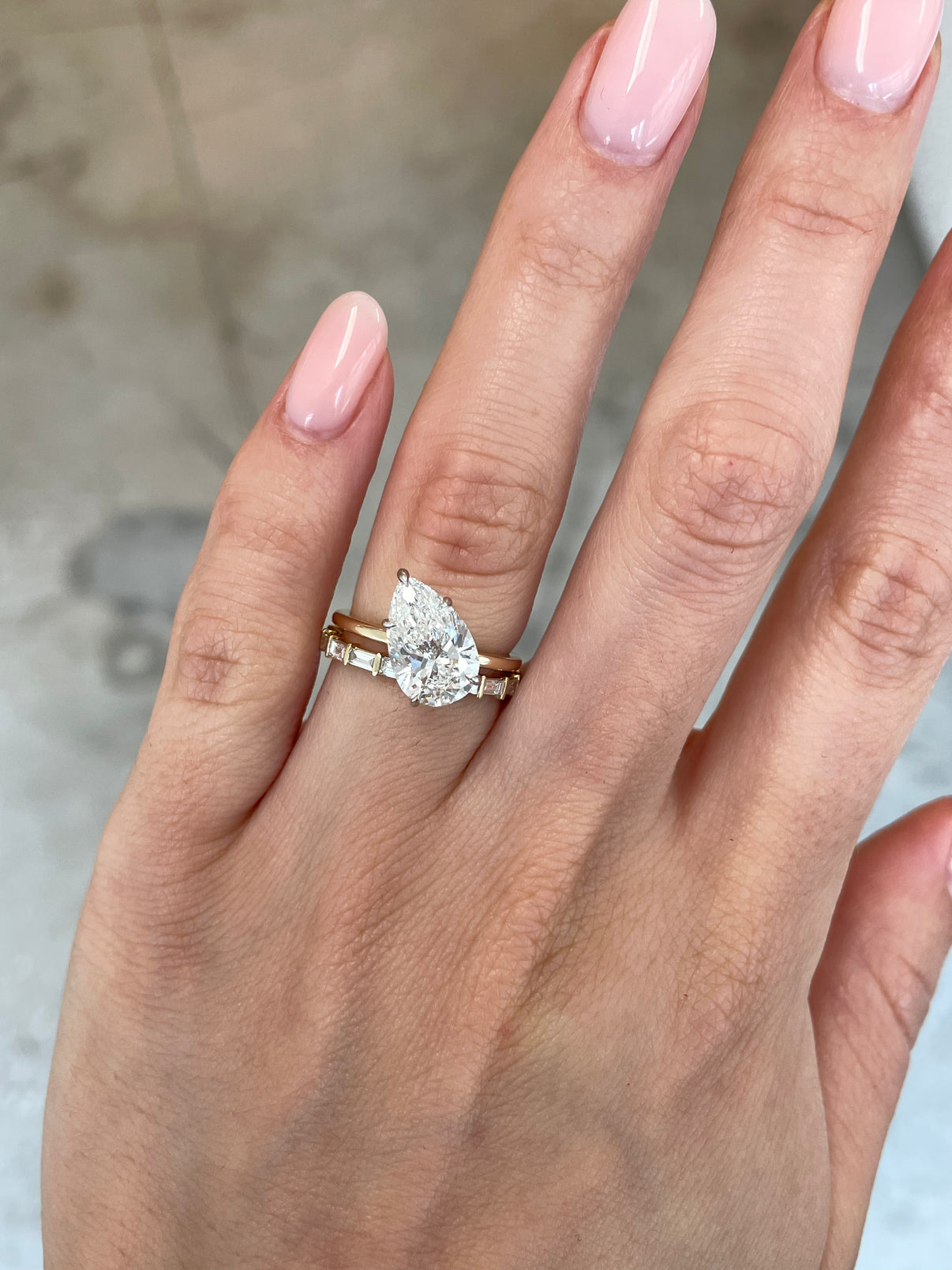 slanted pear engagement ring with baguette bar wedding band