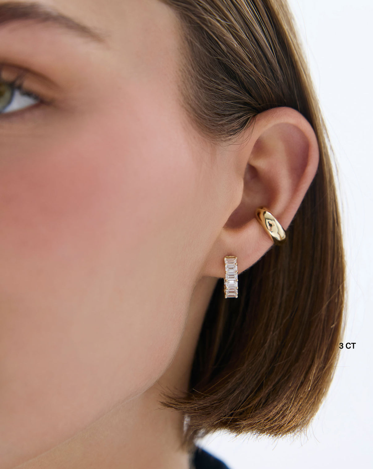 Model showcasing emerald lab 3 carat diamond huggies, side profile view - Ring Concierge global