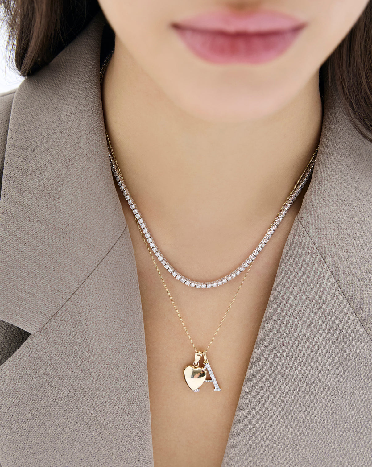 Mini Heart Locket worn on-model paired with tennis necklace and diamond cut curb chain necklace in 14k yellow gold global