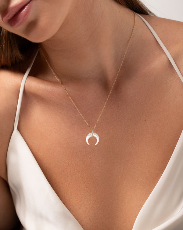 Mother of Pearl + Pavé Horn Necklace in 14kt yellow gold  with model leaning to the side