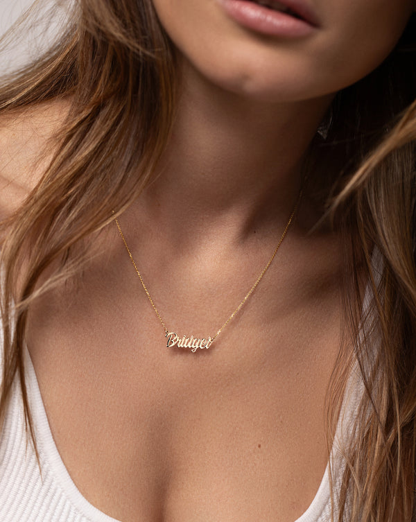 14k yellow gold necklace with the name Bridget in script font shown on model