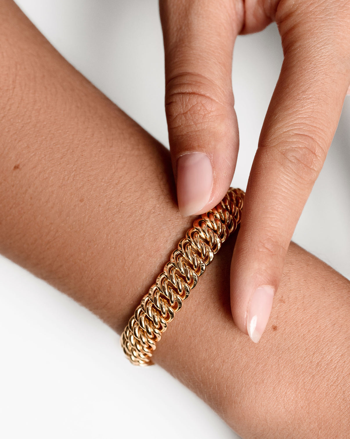 Ring Concierge Bold Gold Braided Chain Bracelet 14k Yellow Gold - on-model with finger showcasing the bracelet on opposite wrist