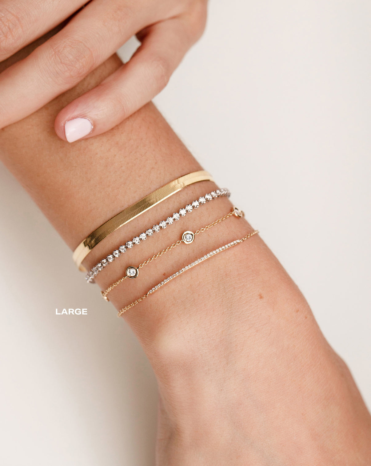 Herringbone Chain Bracelet worn on wrist with the Mini Diamond Tennis Bracelet, Diamond Bezel Set Station Bracelet and Diamond Bar Bracelet LARGE