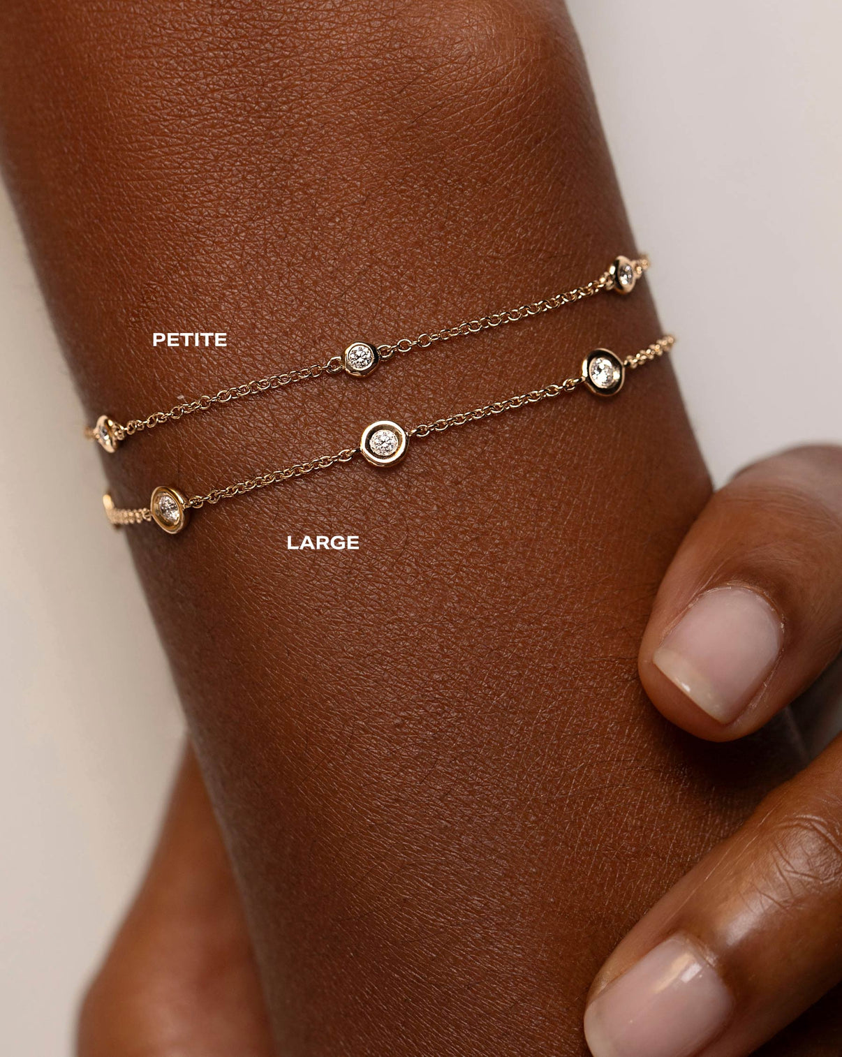 comparison shot of petite bezel-set round diamond station bracelet and large bezel-set round diamond station bracelet on model | 33661633921112 global