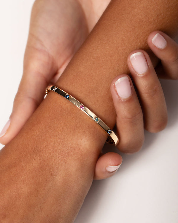 Inlay Birthstone Bangle shown in the 5 stone version on wrist of model