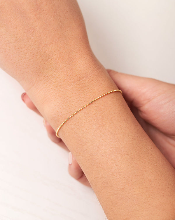 Mini Gold Bead Bracelet shown alone on wrist of model