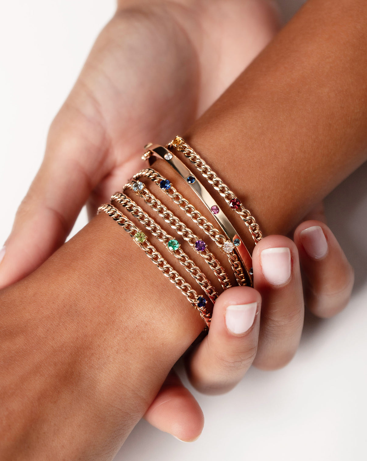 Inlay Birthstone Bangle worn with five Personalized Birthstone Curb Chain Bracelets on wrist of model