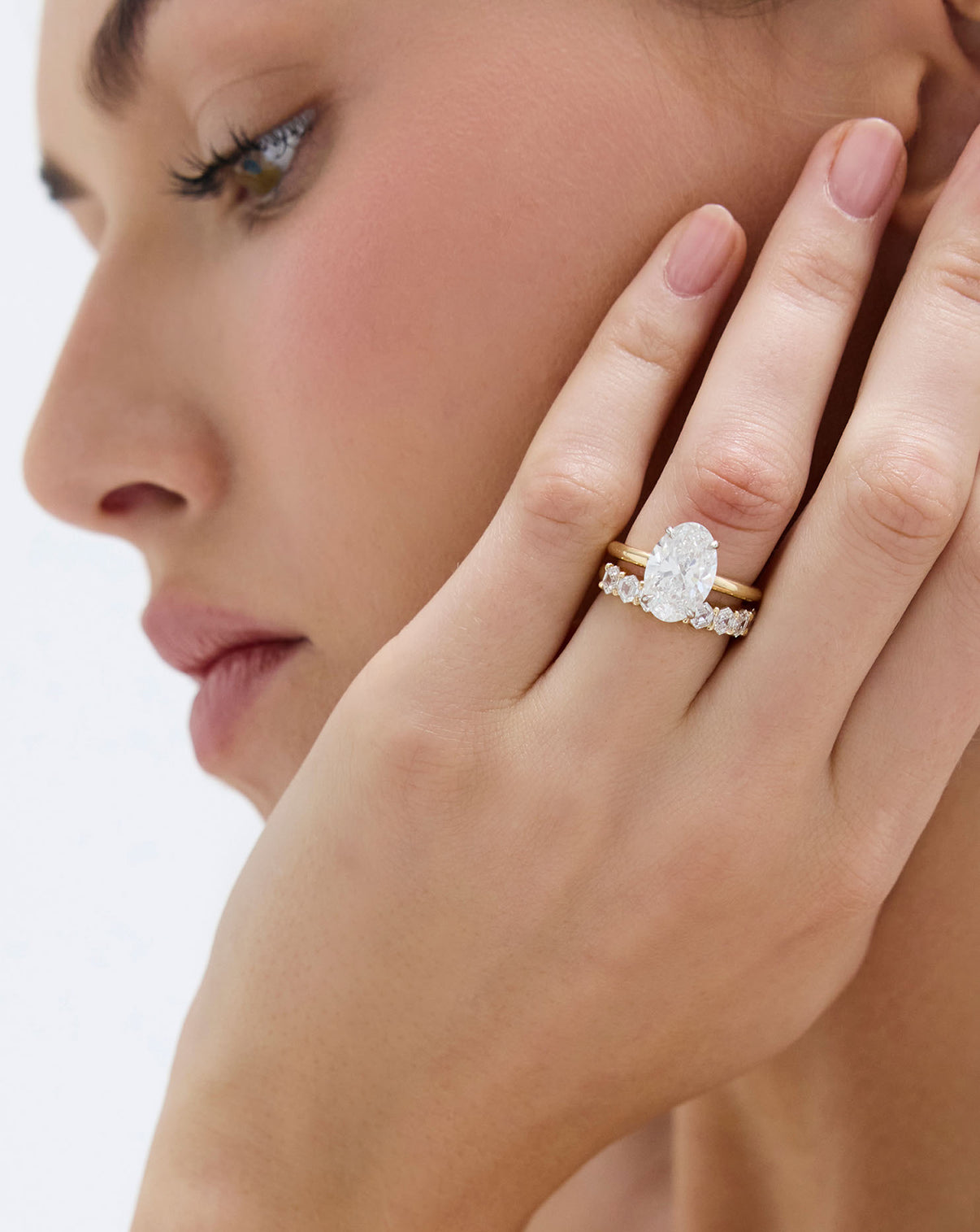 3 carat Oval Diamond in Cloud Solitaire Hidden Halo 14K Yellow Gold paired with a wedding band on model