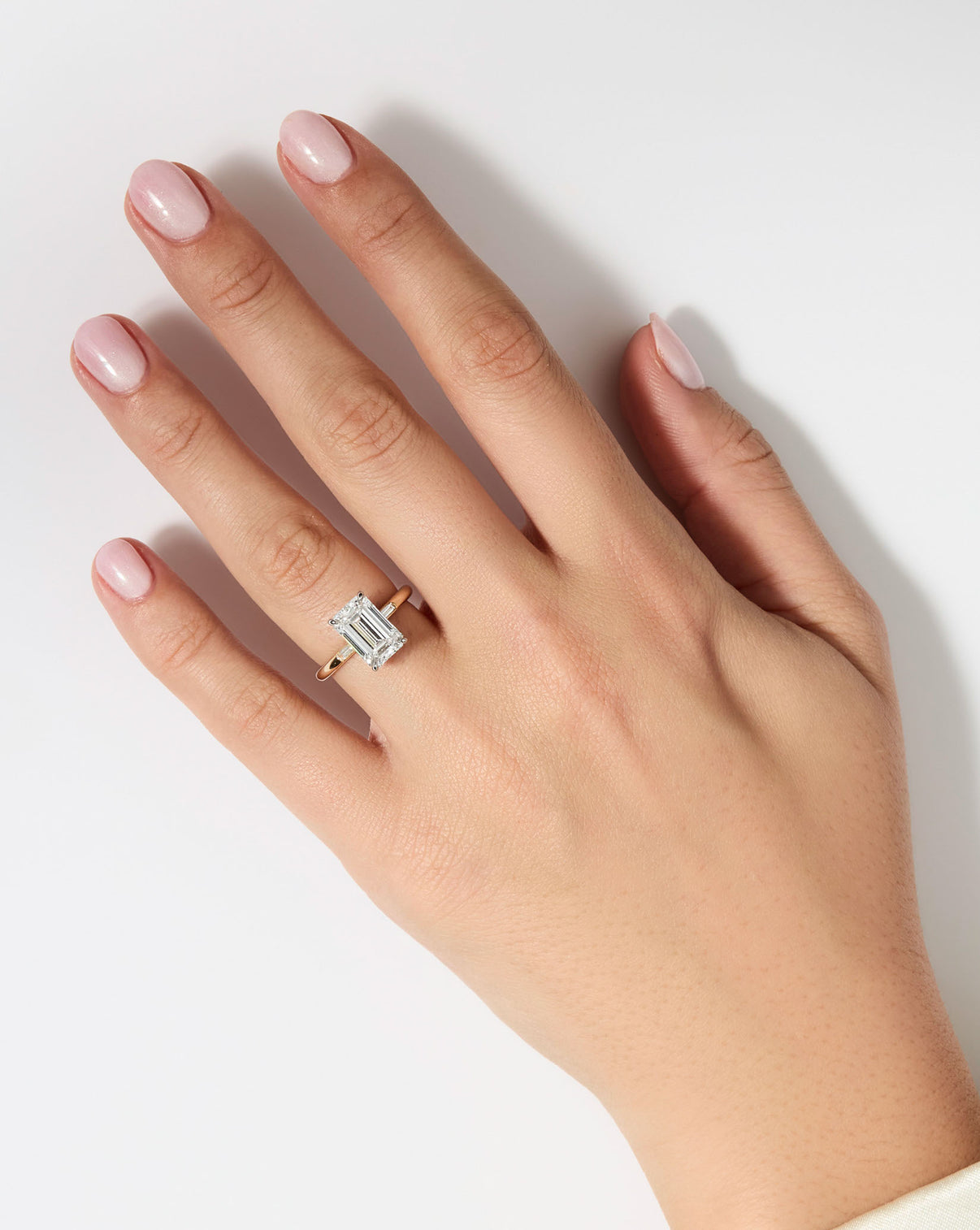 model wearing 3 carat Emerald Diamond Engagement Ring in Yellow Gold Cloud Three Stone with Baguettes