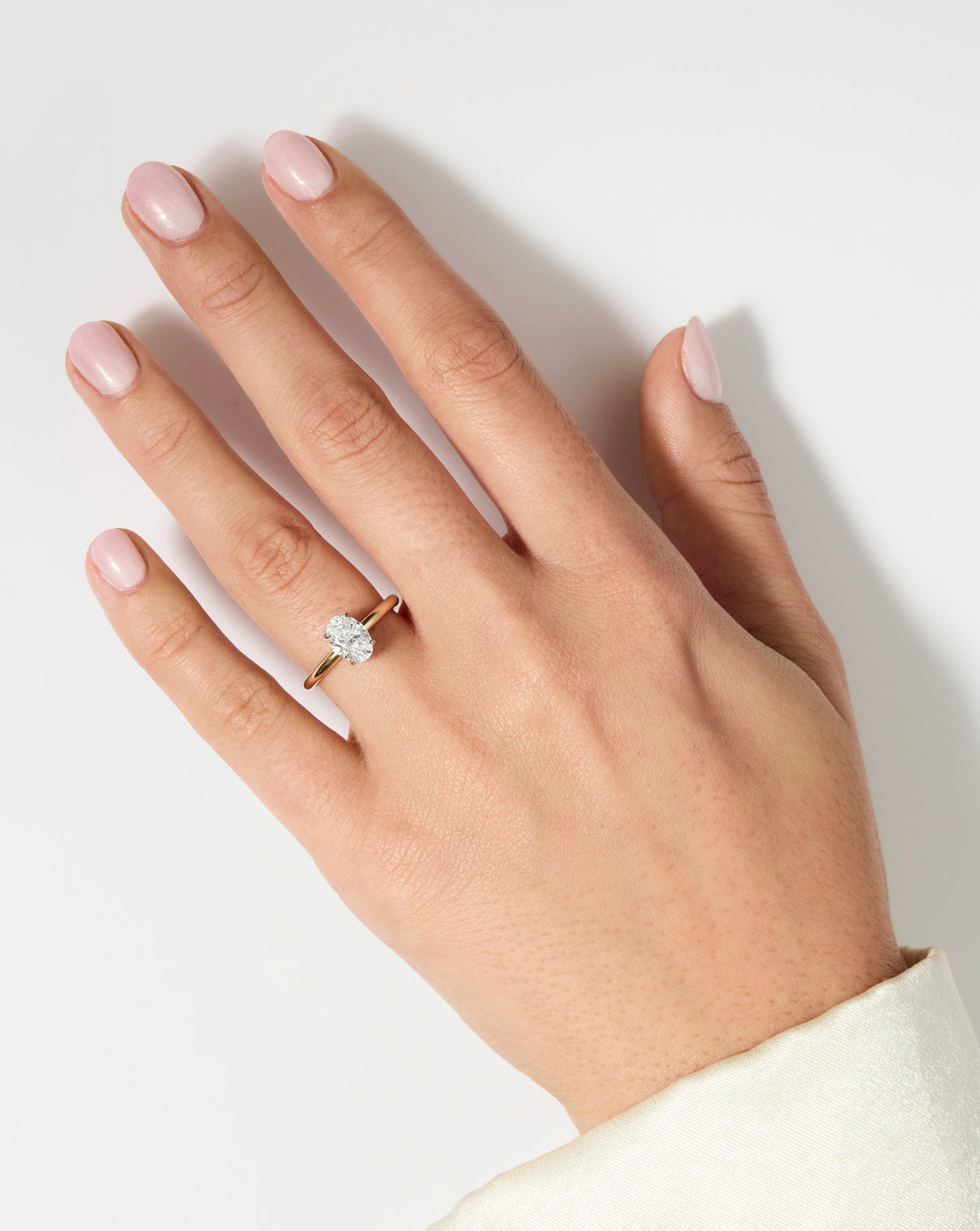 2 carat Oval Diamond Engagement Ring in Yellow Gold Cloud Solitaire setting shown on model's hand