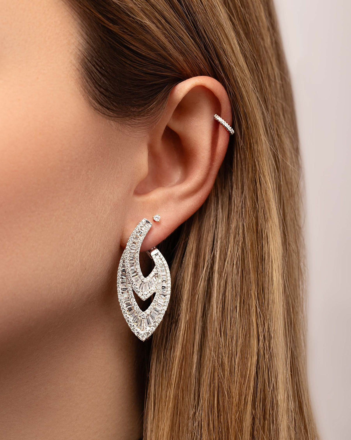 Art Deco Earrings on model styled with tiny diamond stud and mini diamond ear cuff