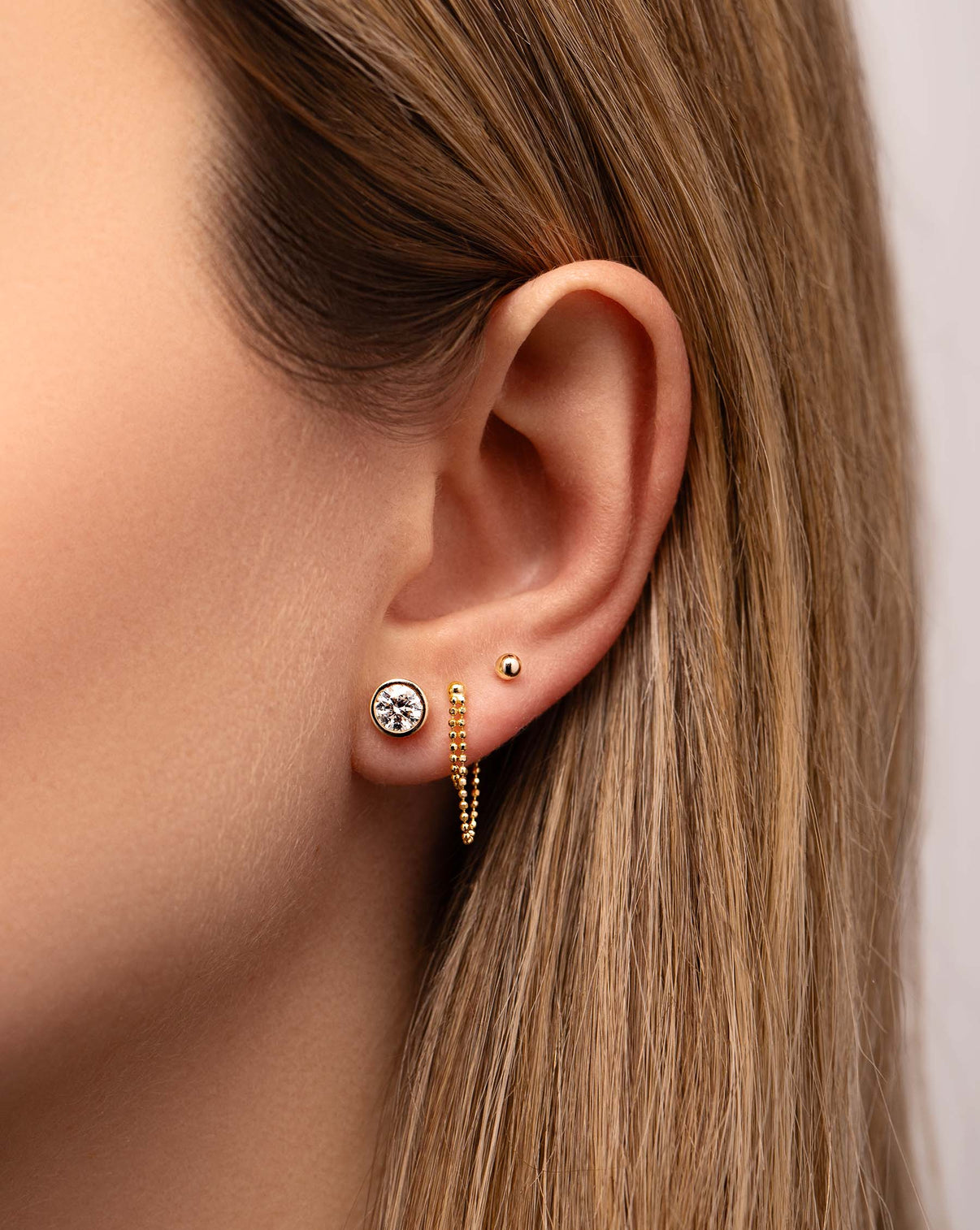 Bezel-Set Classic Diamond Studs styled with 2 other gold earrings on model