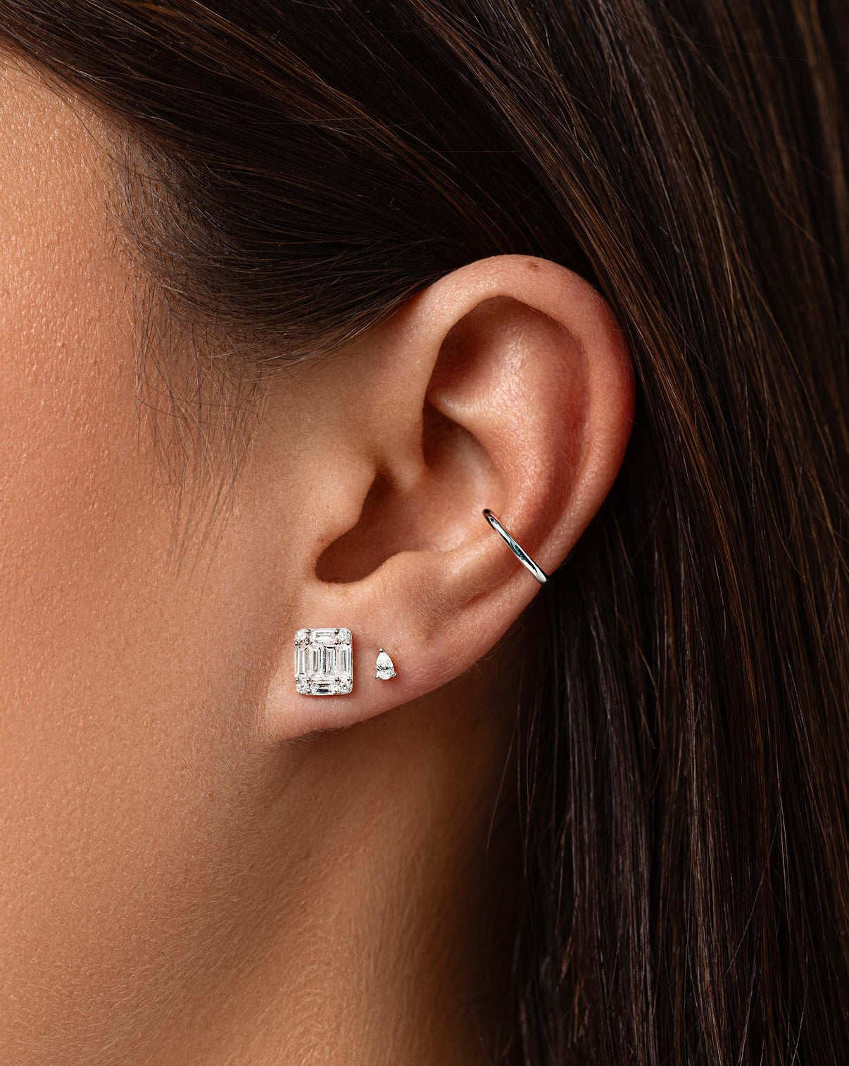Large Emerald Illusion Studs on model styled with tiny pear studs and gold ear cuff