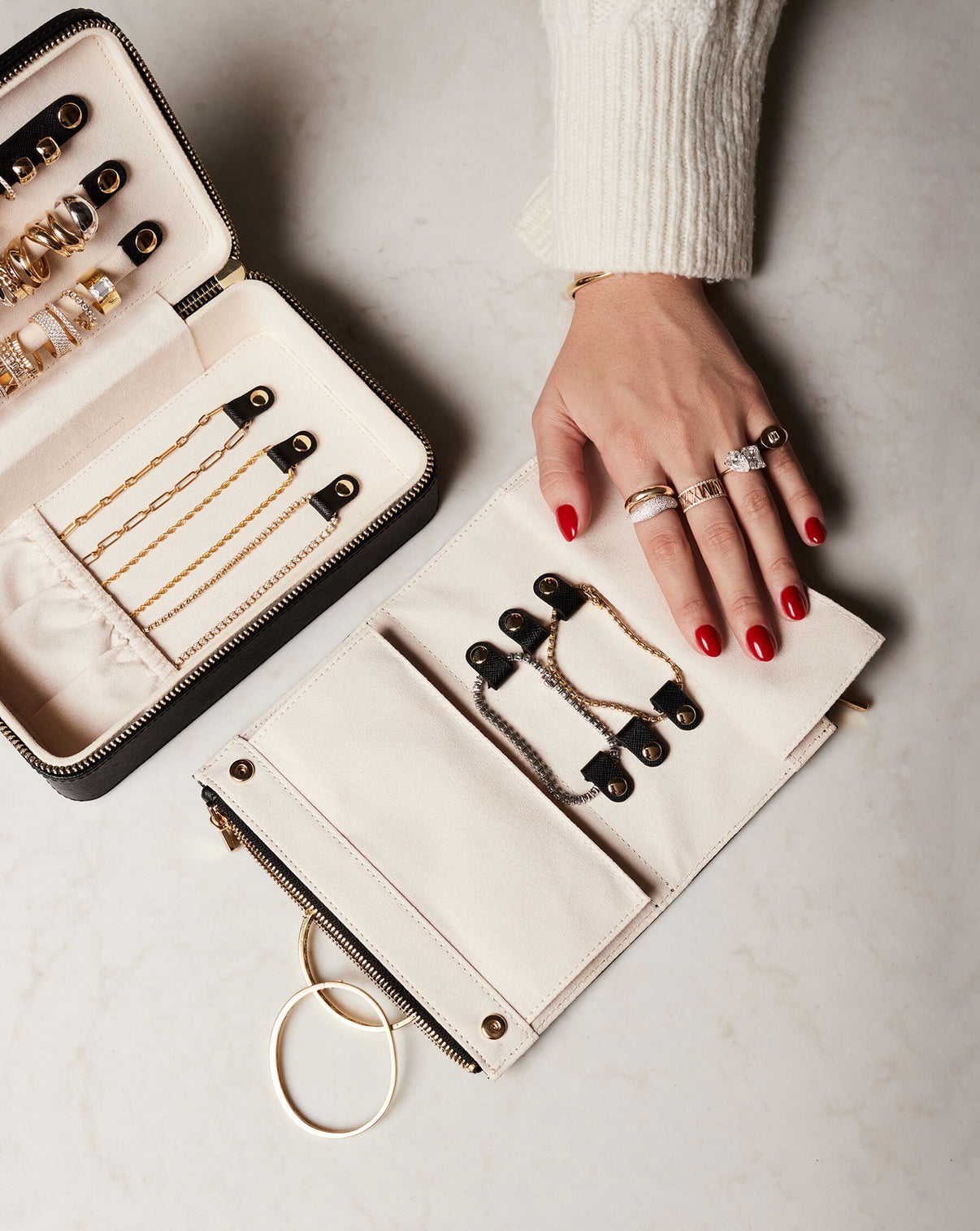Multiway Leather Jewelry Case shown open storing jewelry with model touching an open removable leather pouch showing its storage features while wearing the Gold Cloud Ring, Pave Movement Cloud Ring, Diamond Personalized Roman Numeral Ring, Diamond Signet Pinky Ring and a Toi et Moi Engagement Ring