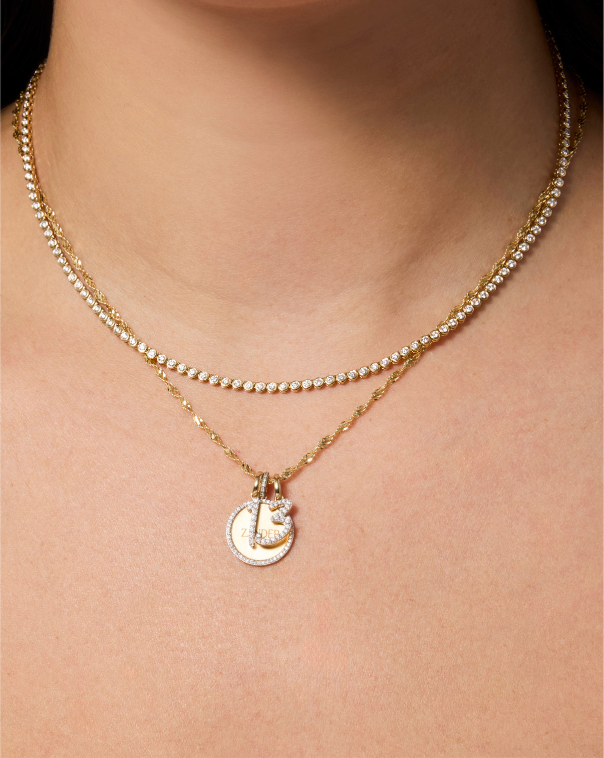 Diamond number pendant on chain necklace styled with tennis necklace and round pave pendant