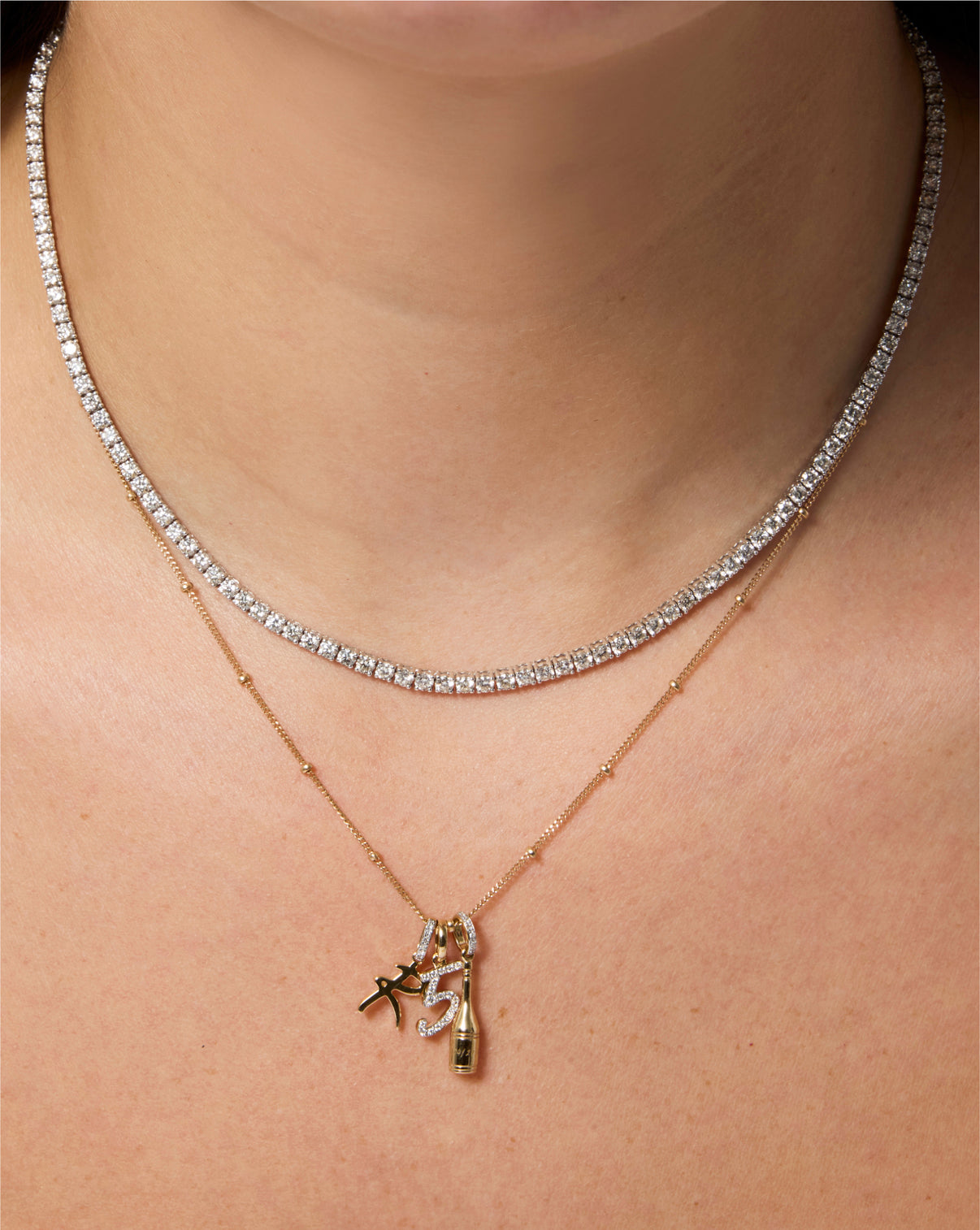Diamond number pendant on chain necklace styled with tennis necklace and other pendants