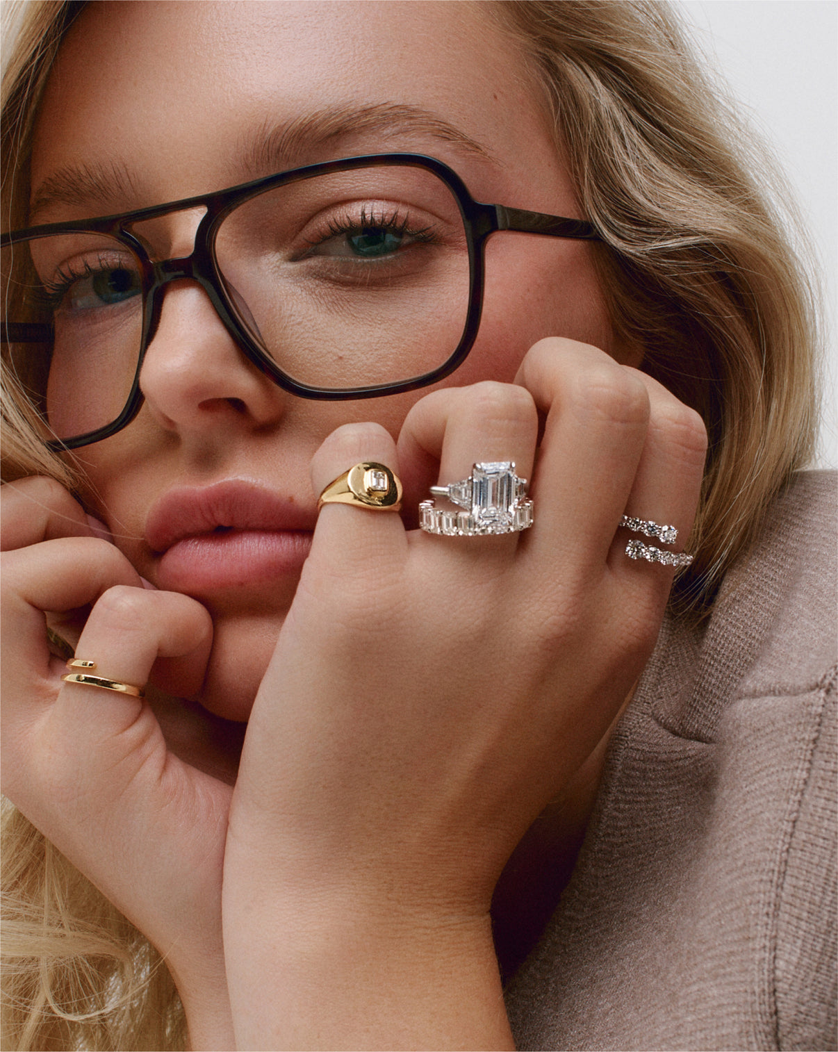 emerald diamond eternity band and engagement ring on model wearing glasses global