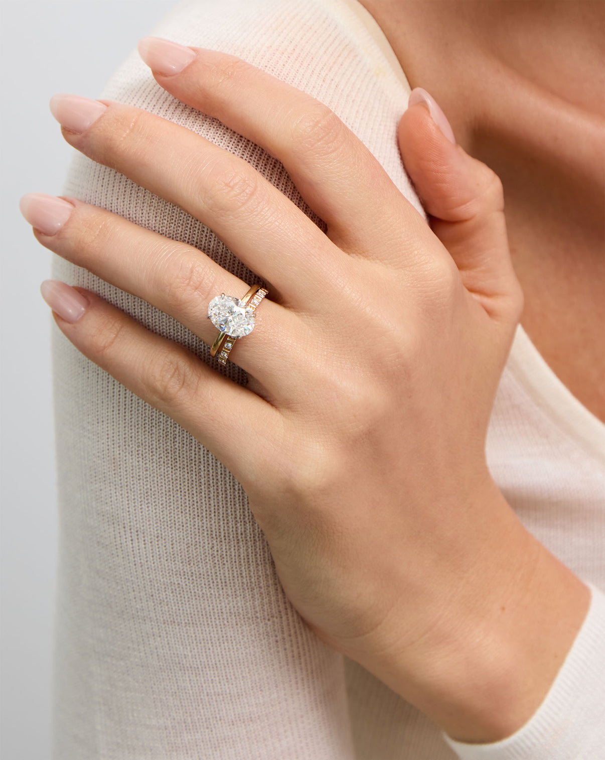 Fluted Diamond Ring styled on model's ring finger with oval engagement ring global