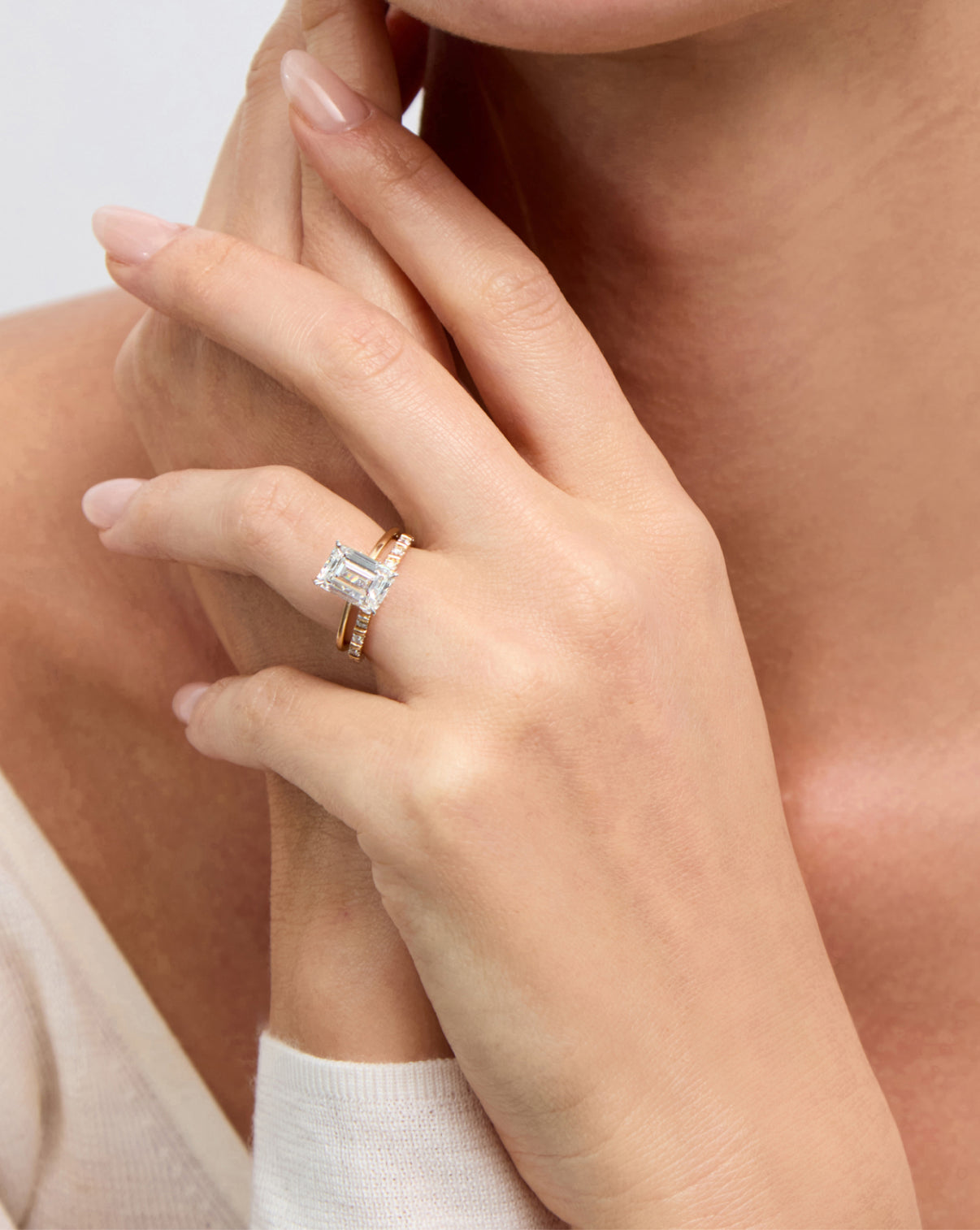 Fluted Diamond Ring styled on model's ring finger with emerald engagement ring global