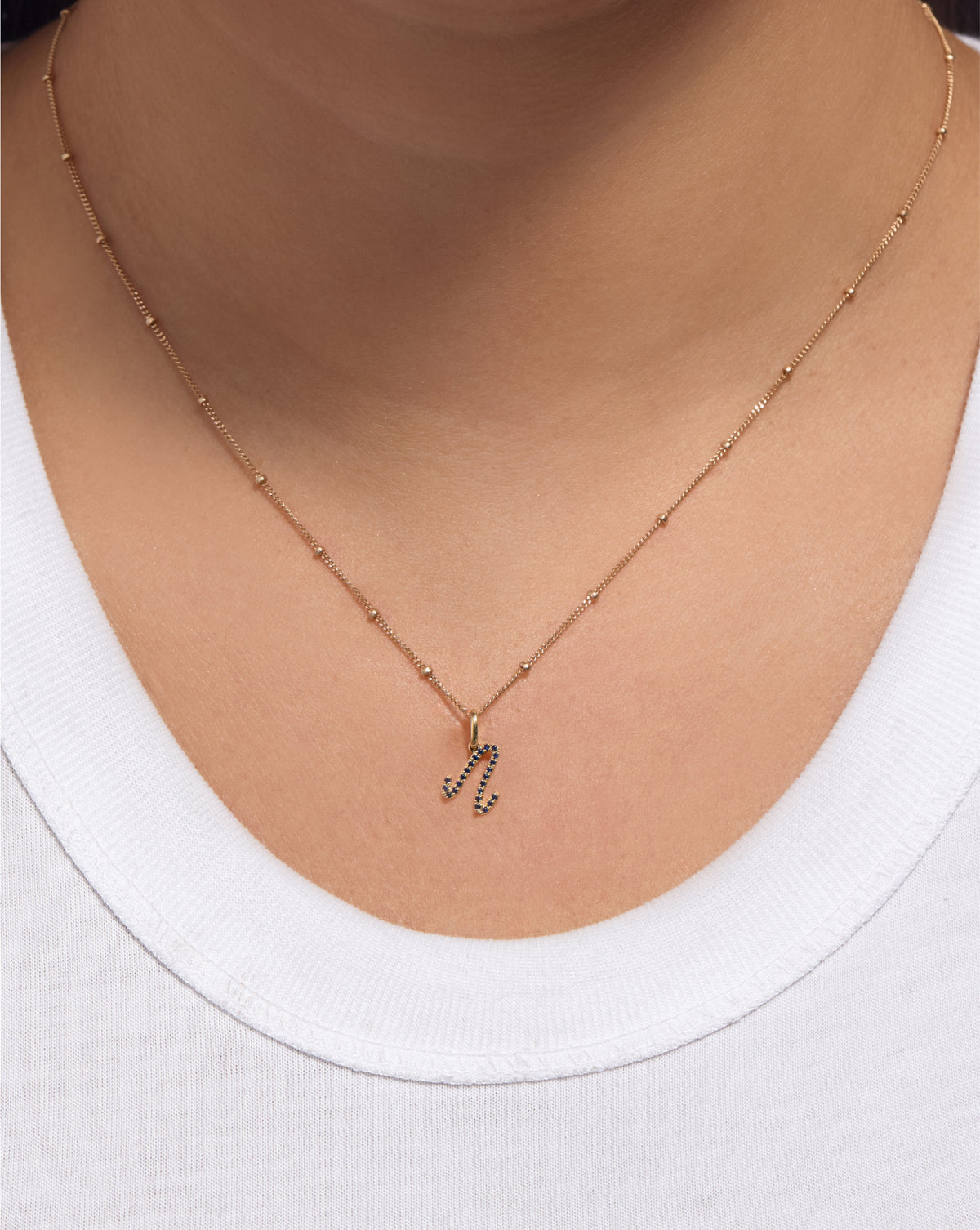 Gemstone Script Initial Pendant in sapphire styled solo on chain on model