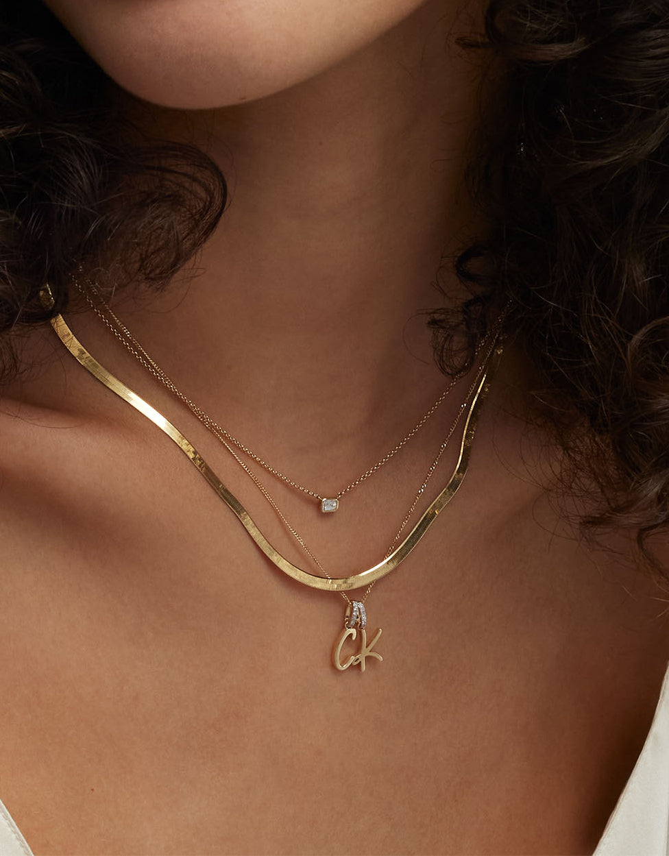Script Initial Necklace styled on model with Script Initial Pendant on the same chain and 2 other necklaces