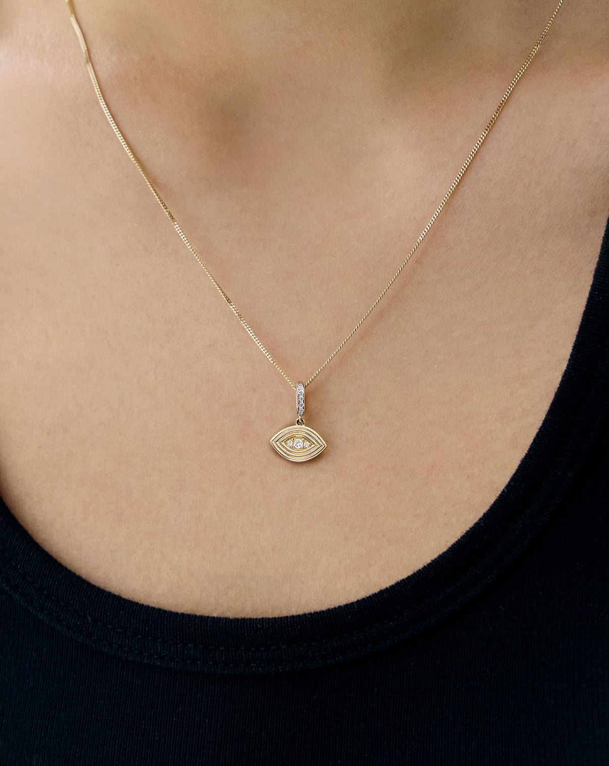 evil eye charm on yellow gold necklace worn on model