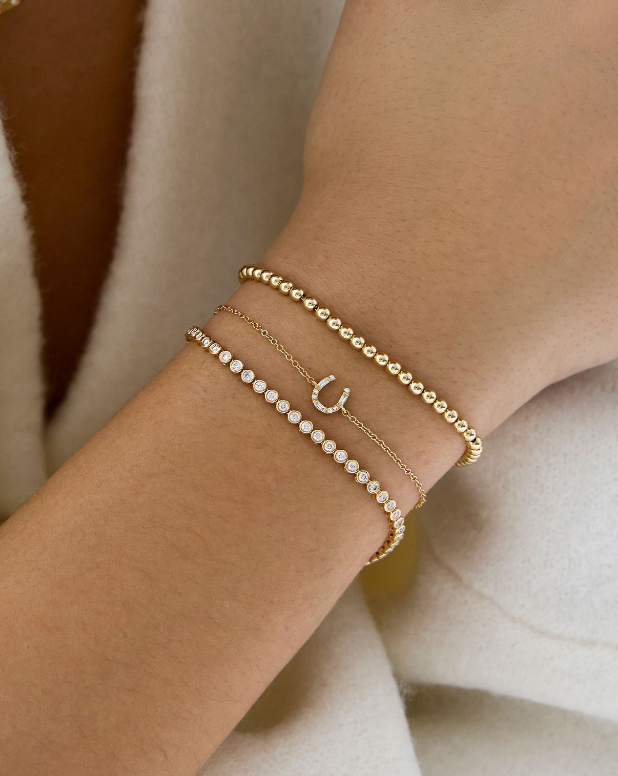 Horseshoe Bracelet shown on wrist with tennis and bead bracelet