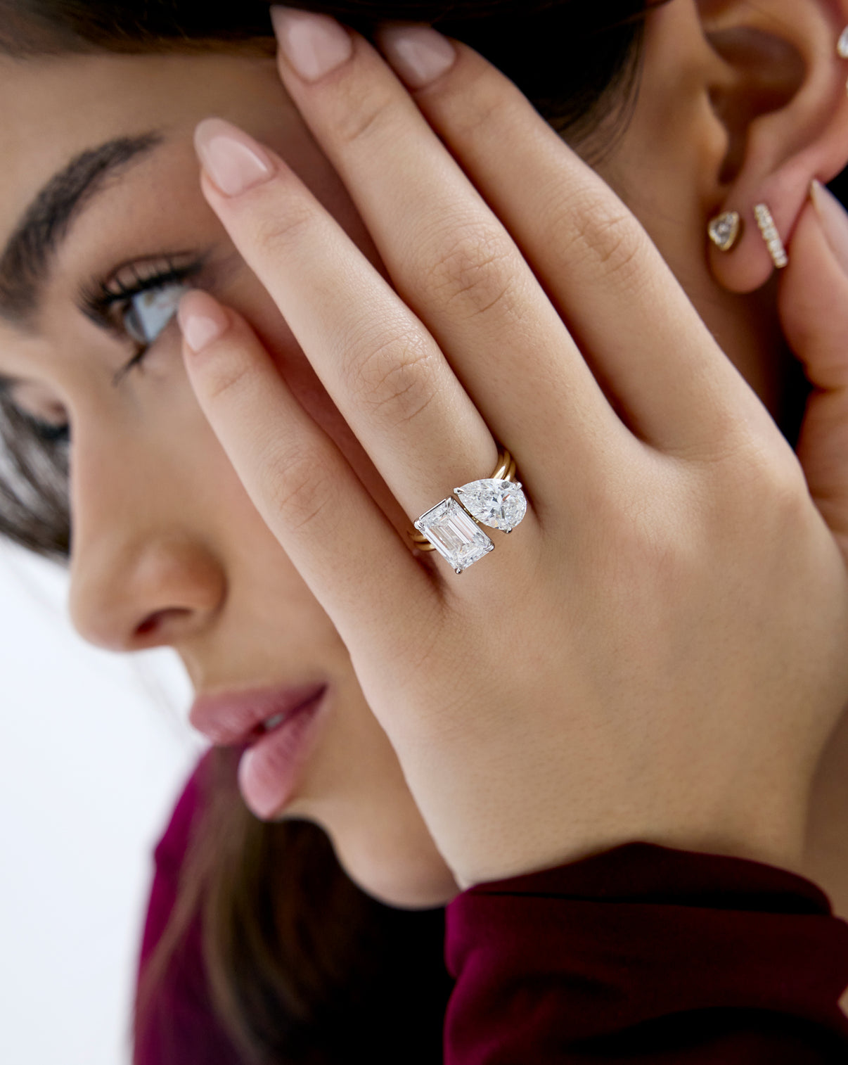 close up of model wearing Stacked 5.21 Carat Emerald & Pear Whisper Thin® Duet diamond engagement ring in 14K Yellow Gold