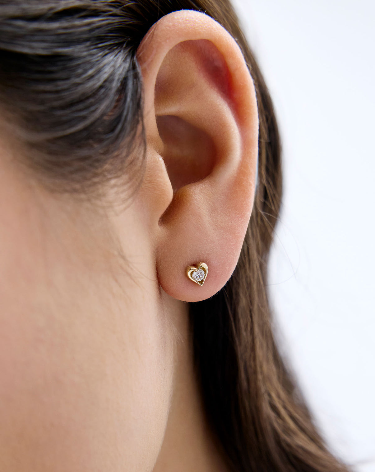 14K Yellow Gold Framed Lab Diamond Heart Studs shown on model's ear