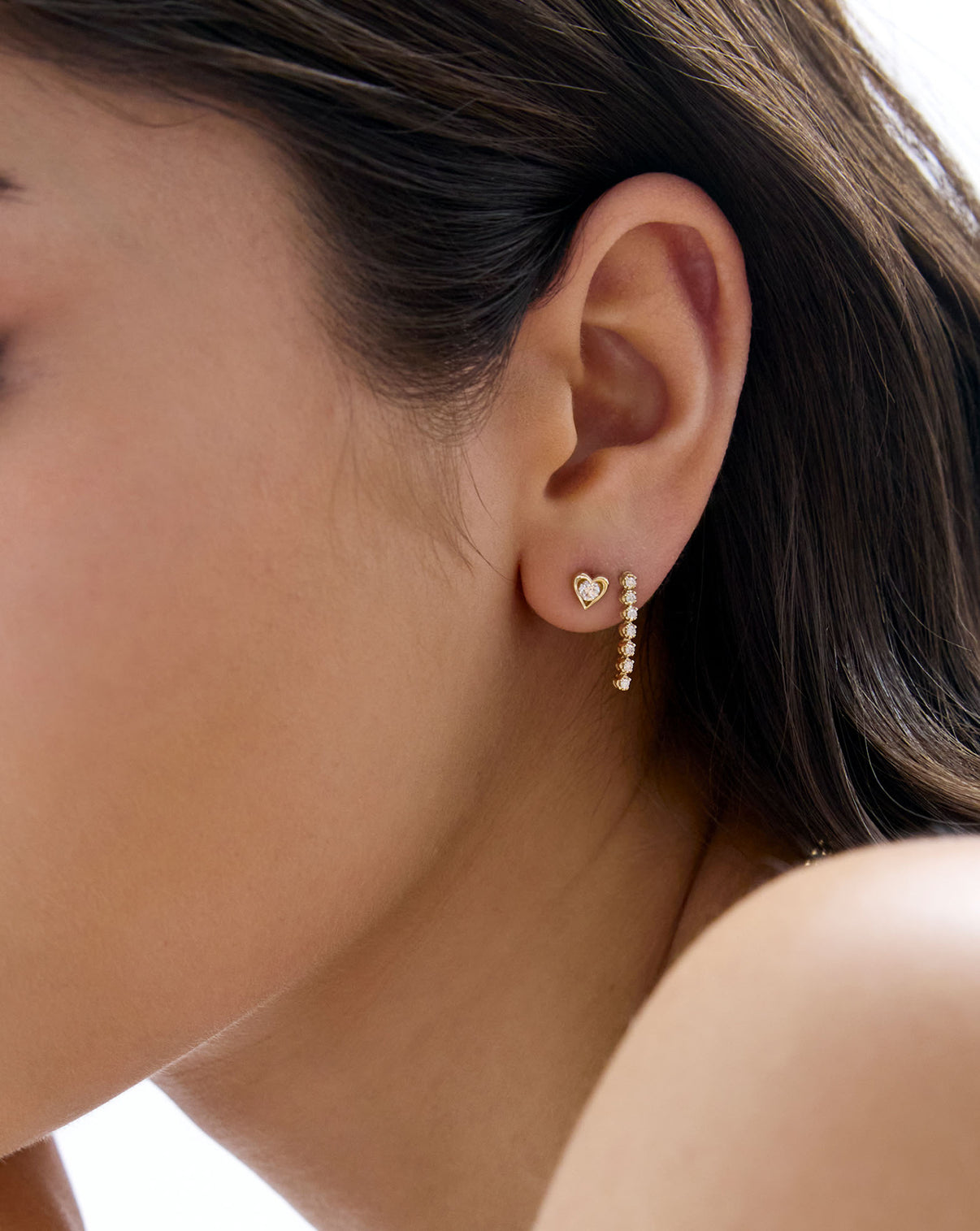 14K Yellow Gold Framed Lab Diamond Heart Studs styled with diamond tennis drop earrings on model's ear