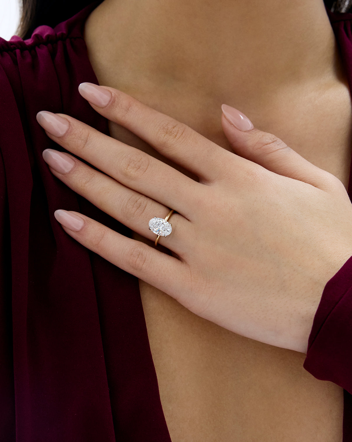 Close up of model wearing 2.60 carat Oval ring of the 4.70 Oval & Pear Whisper Thin® Duet diamond Engagement ring in 14K Yellow Gold