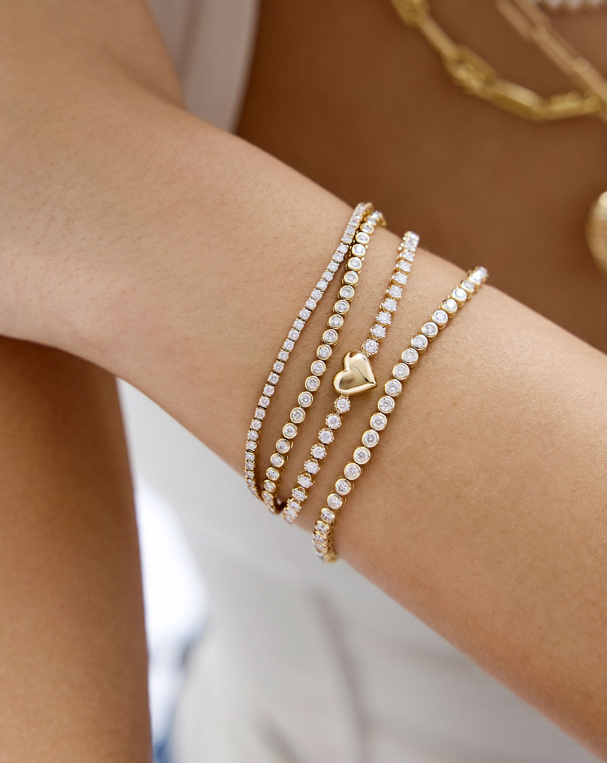14K Yellow Gold Heart Lab Diamond Tennis Bracelet shown without engraving and styled with various tennis bracelets