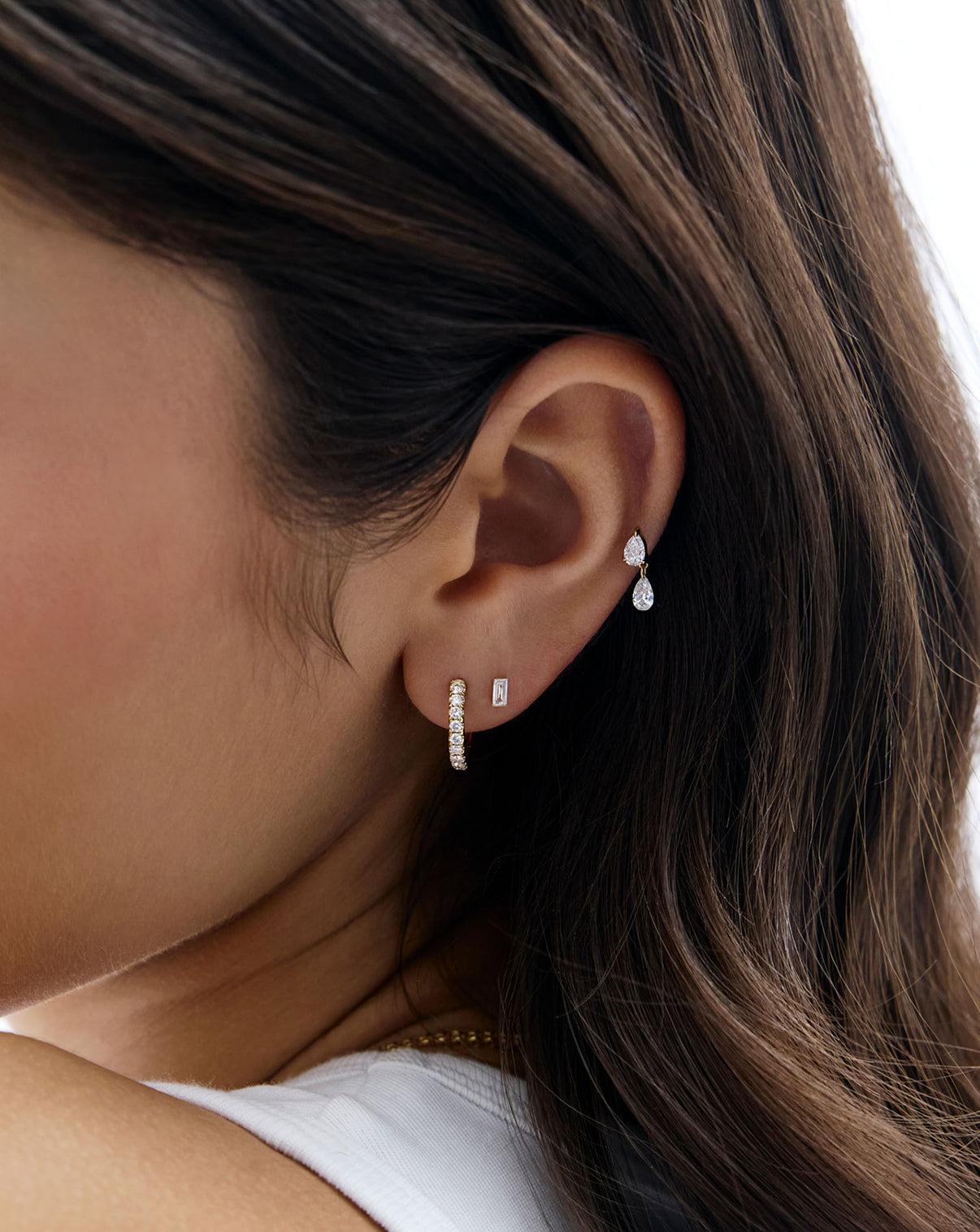 Pearl Drop Lab Diamond Flatback Earring shown close up on model's ear styled with a diamond huggie and the mini emerald lab diamond flatback earring